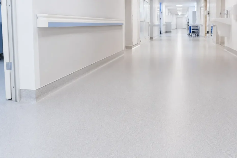 A clean hospital corridor with a joint-free, coved sheet-vinyl clinical floor