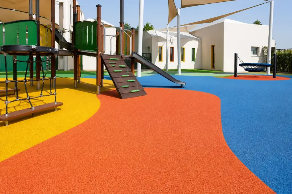 A colourful poured EPDM rubber playground surface beneath play equipment