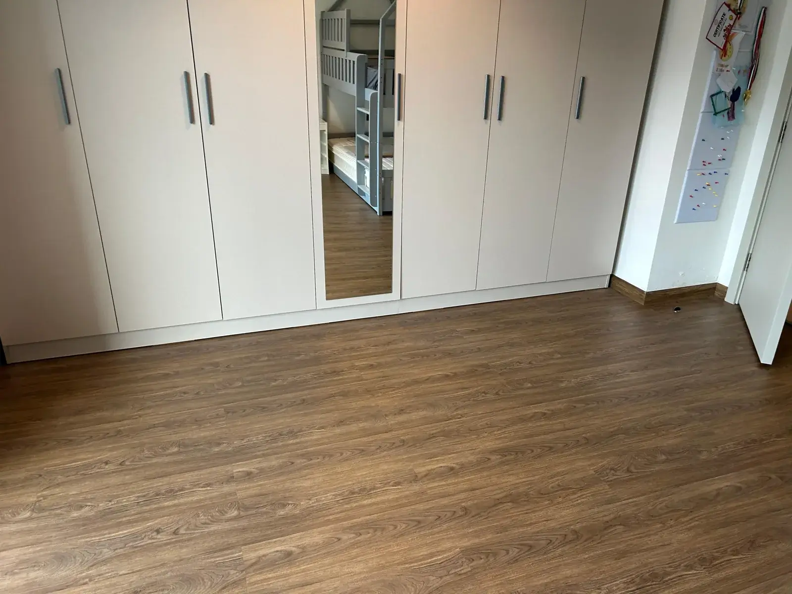 Brown SPC flooring by fitted wardrobes in a JVT villa bedroom, Dubai