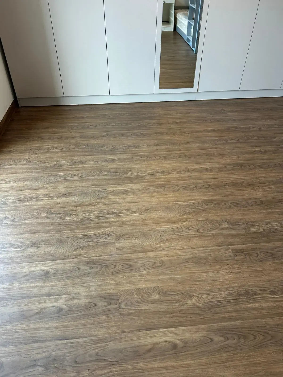Brown walnut wood-look SPC plank detail, JVT District 8 villa Dubai