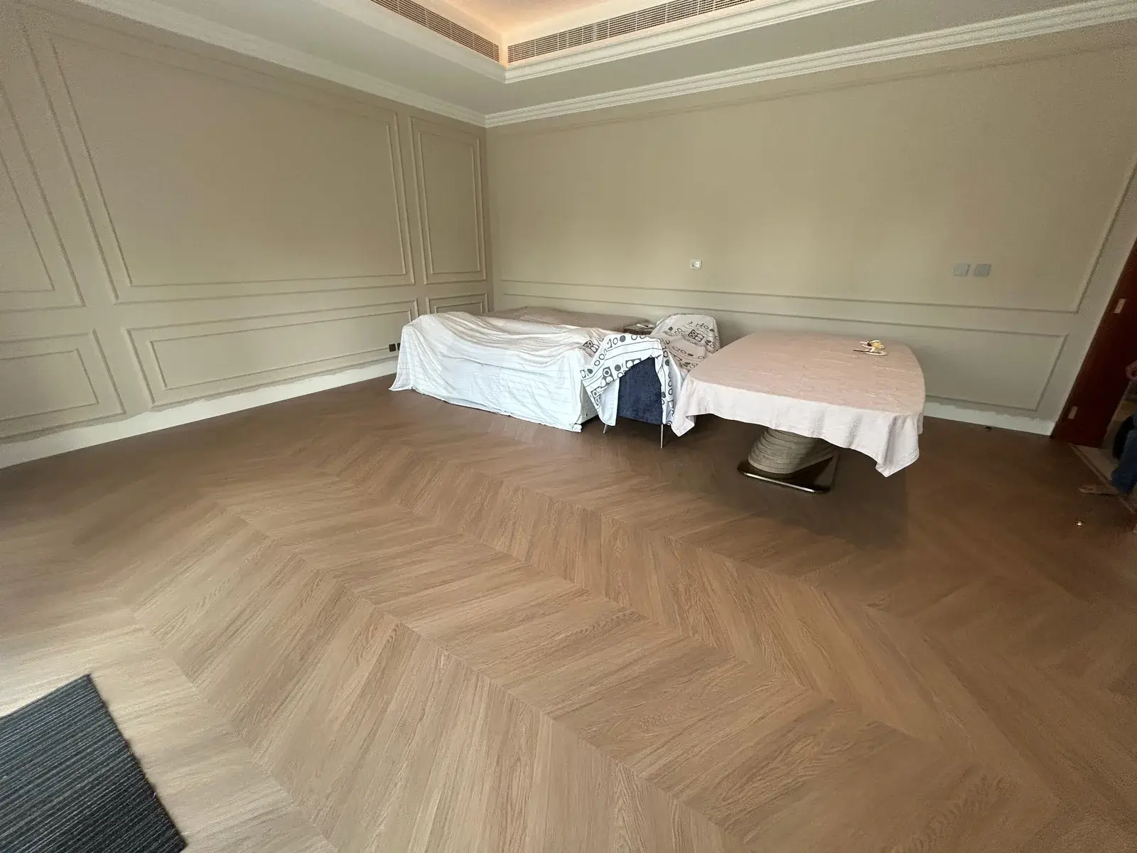 Large-format chevron wood-look flooring in a Costa Brava living room, DAMAC Lagoons Dubai