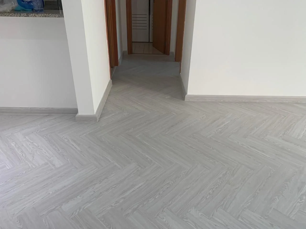 Grey herringbone SPC flooring in an apartment hallway, Al Zarooni Building Al Mamzar Dubai