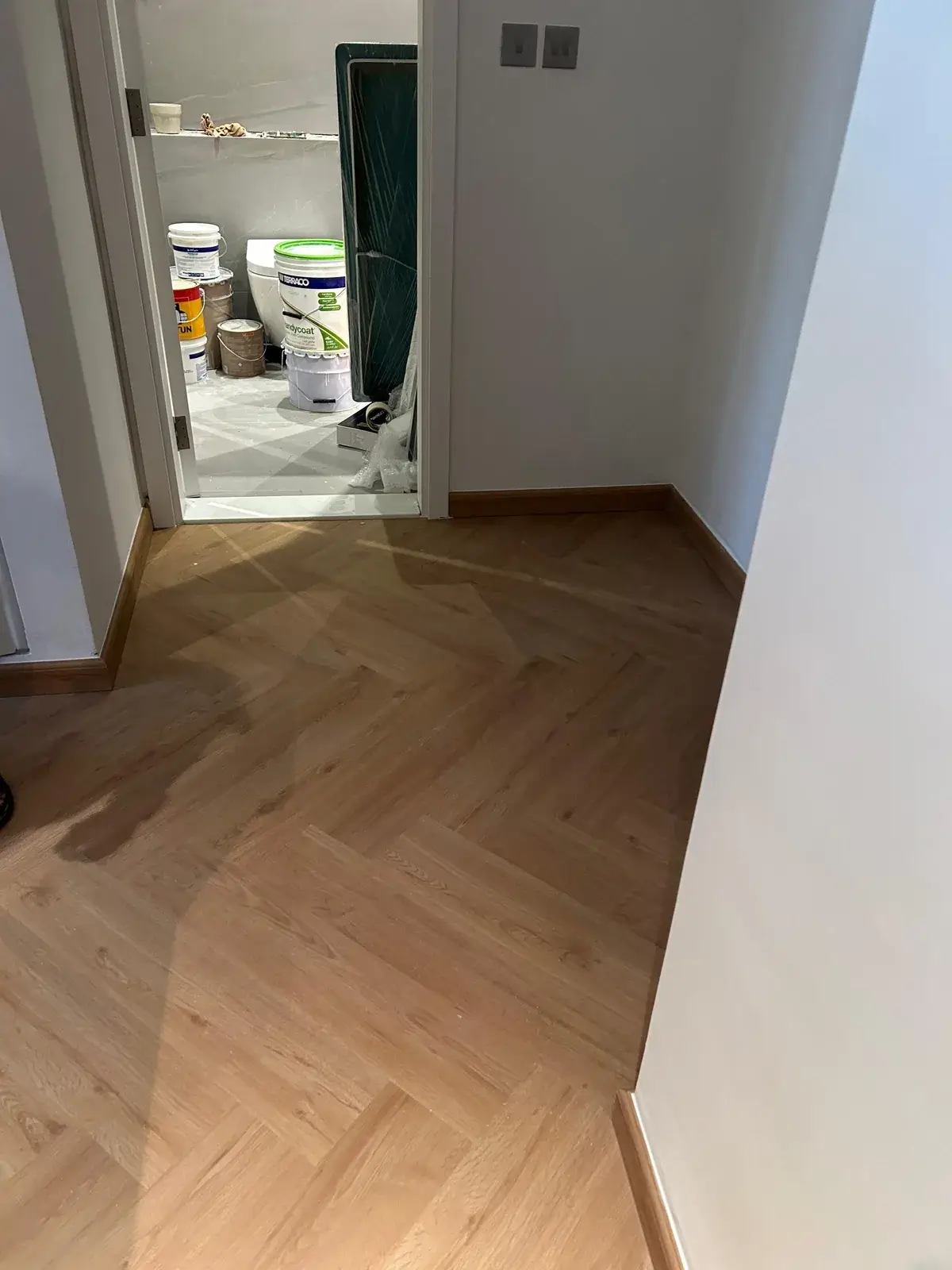 Herringbone SPC flooring along a corridor in a Valia Tower apartment, Dubai