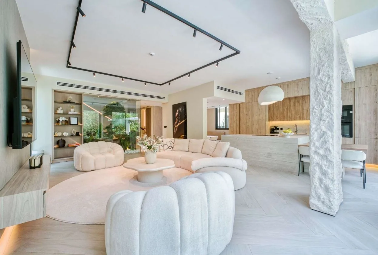 Chevron wood-look SPC flooring and a round area rug in a Tilal Al Ghaf villa living room, Dubai
