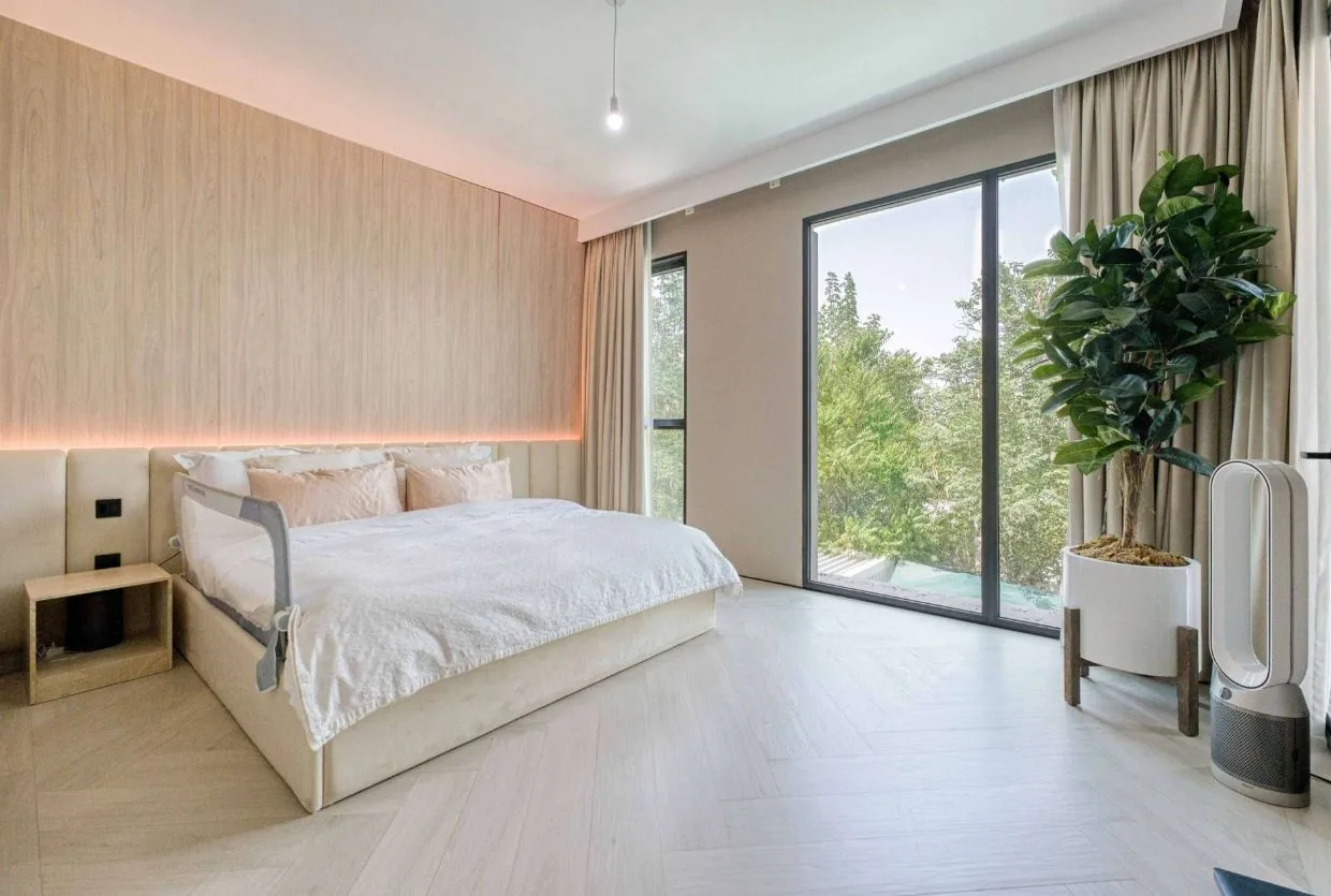 Light oak wood-look SPC chevron flooring in a villa master bedroom, Dubai