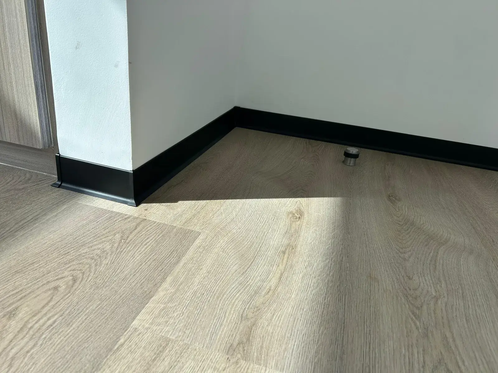 Black skirting mitred around an external corner over SPC flooring, Al Nahda 2 Dubai