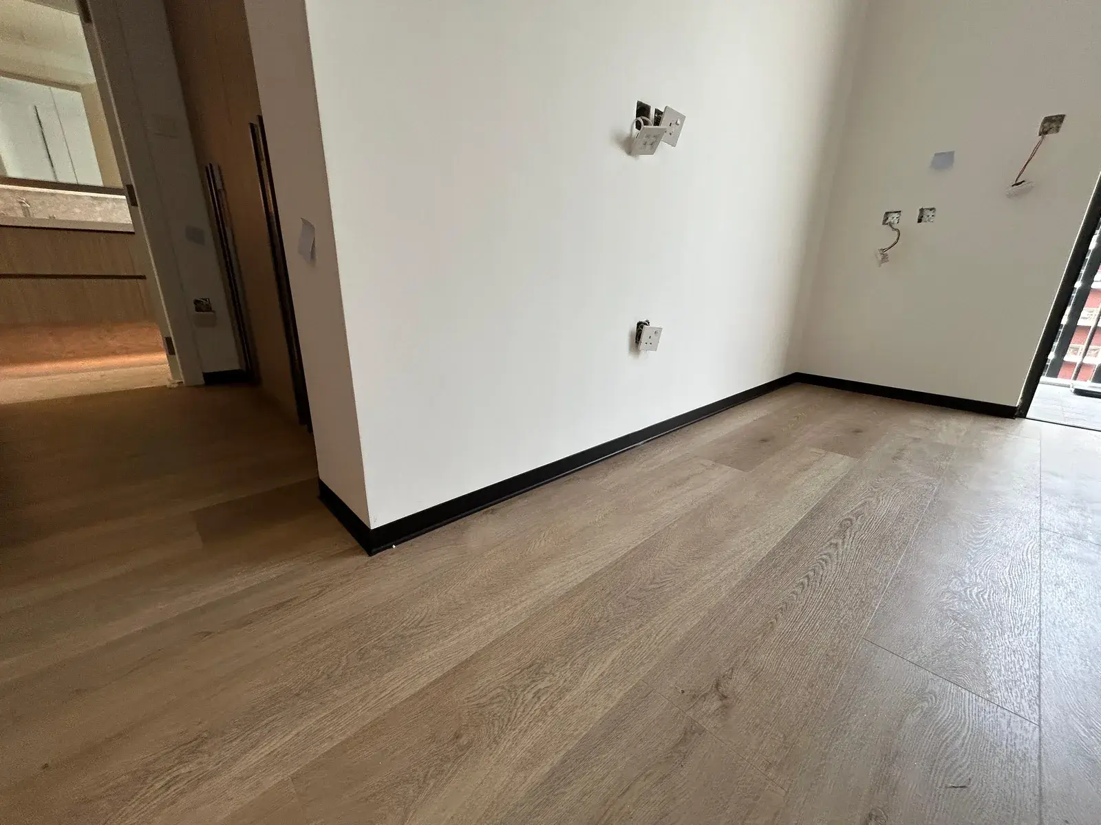 Pale oak SPC flooring across a new-build apartment room, Al Nahda 2 Dubai