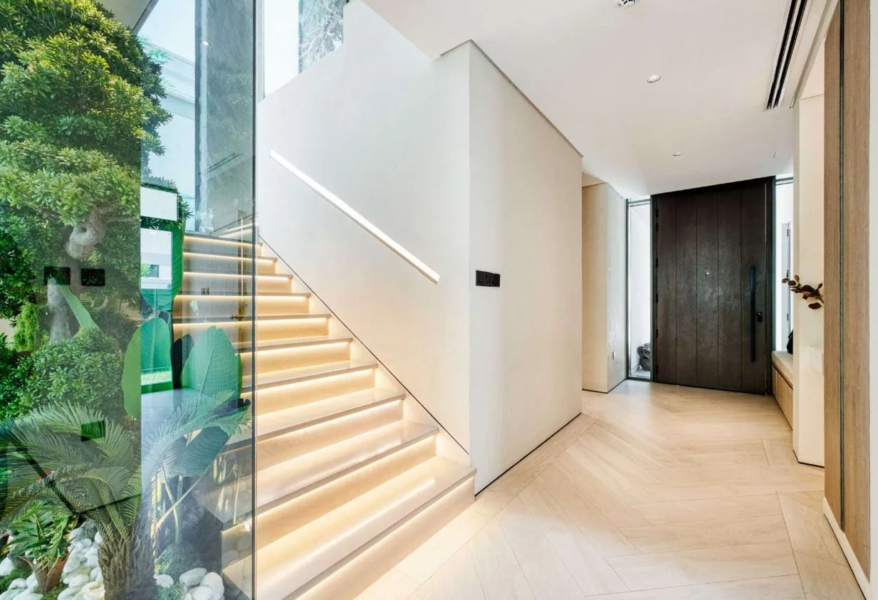 Chevron wood-look SPC flooring at the entrance and staircase of a Tilal Al Ghaf villa, Dubai