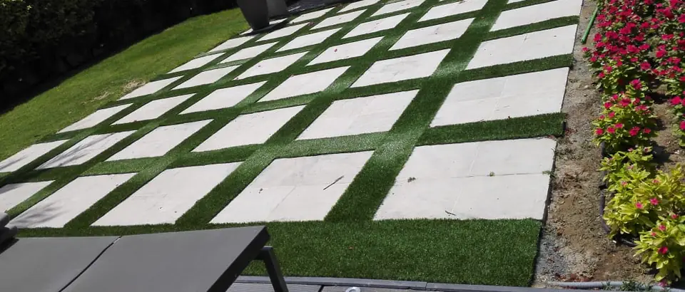 Artificial grass strips running between large pavers across a villa terrace in Dubai