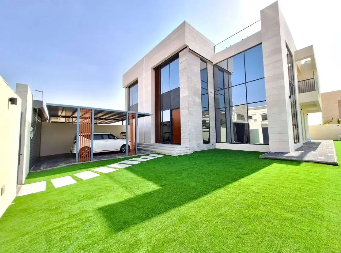 Artificial grass front garden with stepping stones at a villa in Al Suyoh, Sharjah