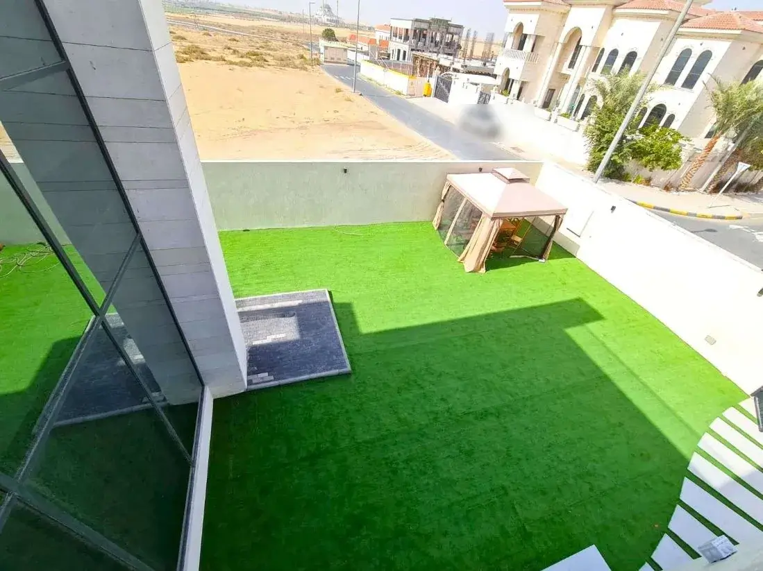 Elevated view of an artificial grass lawn at a Sharjah villa showing the full fitted area