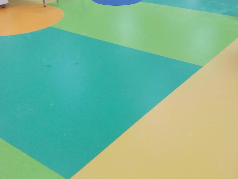 Close view of inlaid circles and colour bands in nursery sheet vinyl flooring, showing the welded seams