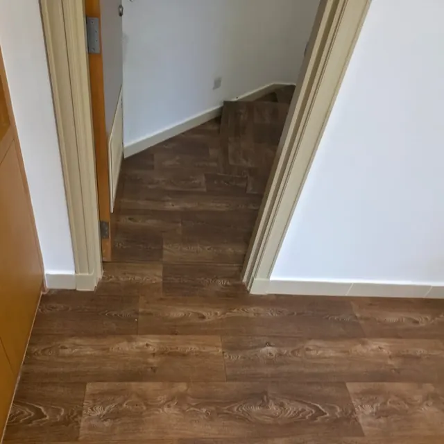 Wood-look sheet vinyl flooring carrying through a doorway without a threshold strip, Y Tower Abu Dhabi
