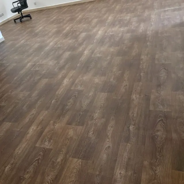Wood-look sheet vinyl flooring running the length of a living area at Y Tower, Al Reem Island