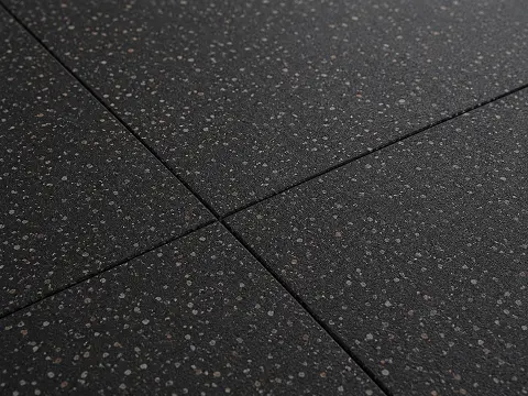 Heavy-duty rubber flooring tiles with a speckled finish for a free-weight zone
