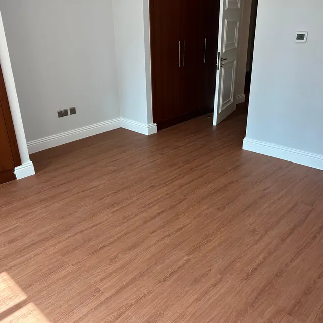 WPC plank flooring in a bedroom with retained dark timber fitted wardrobes, Enaya Residences JVT Dubai