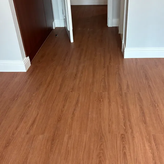 WPC plank flooring finishing against the dark plinth of a retained fitted wardrobe, Enaya Residences JVT